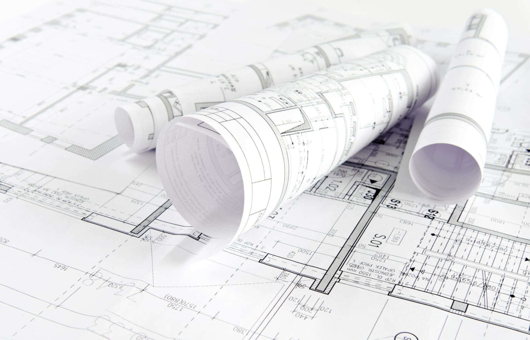 Rolled architectural blueprints on floor plans